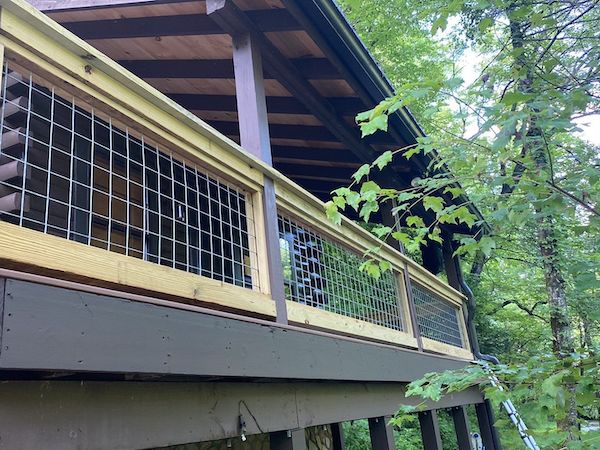 Stained deck railing and stone chimney